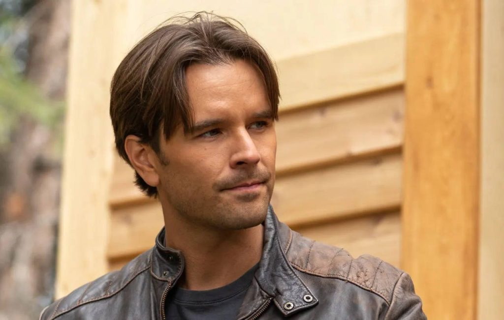 Graham Wardle portrait in distressed brown leather jacket rustic wooden background wallpaper