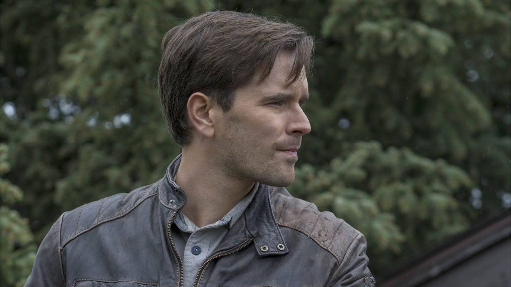 Graham Wardle side profile portrait in leather jacket with blurred forest background calm expression Wallpaper