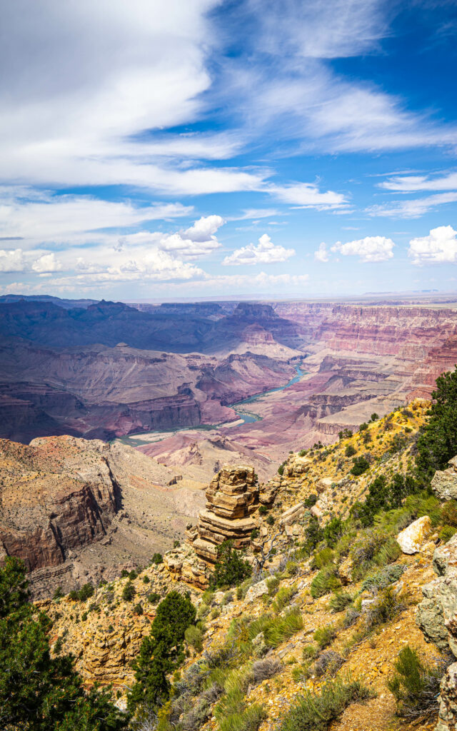 Grand Canyon landscape with layered rock formations cliffs and vivid blue sky with clouds Wallpaper