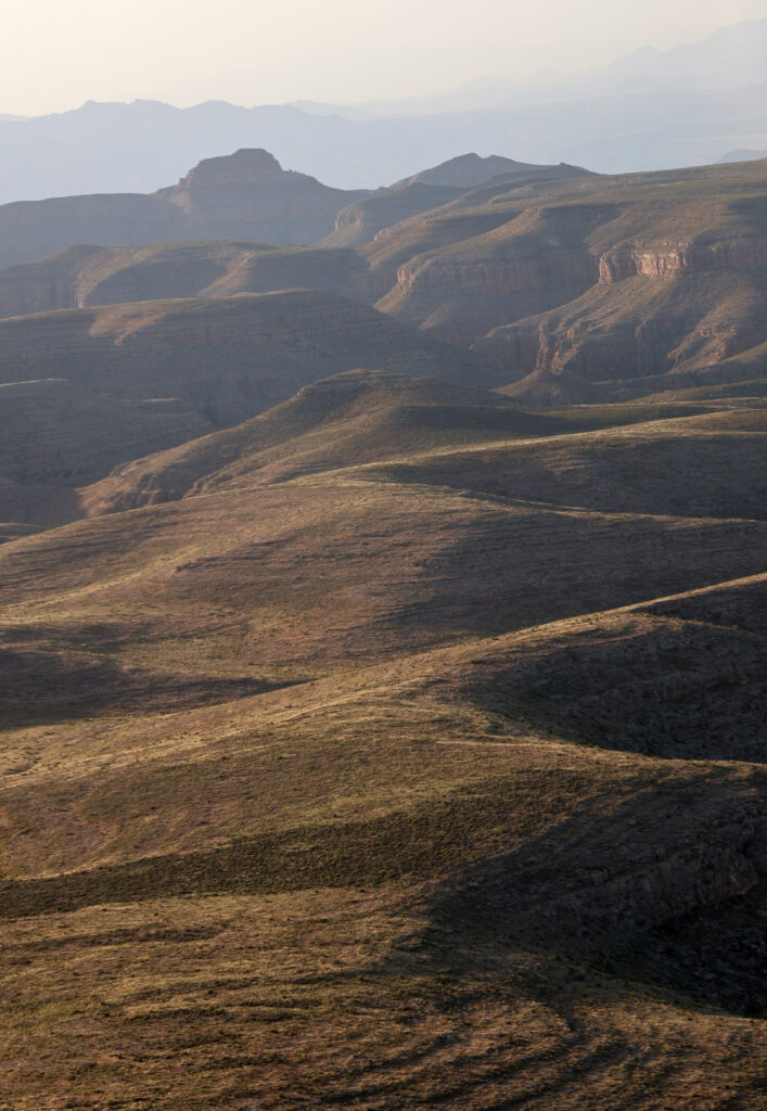 Grand Canyon wallpaper showcasing layered ridges earthy tones soft natural light panoramic view