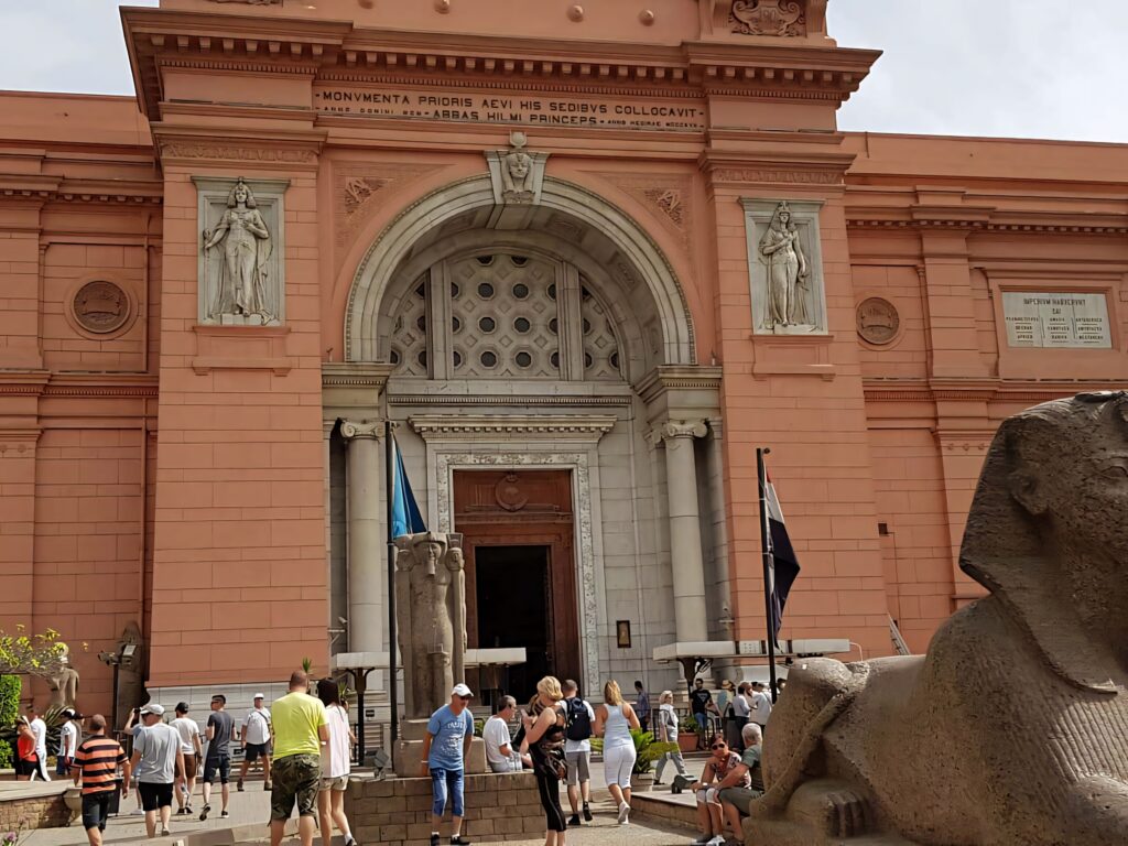 Neo-classical Egyptian Museum entrance with terracotta facade detailed statues and arched doorway Wallpaper