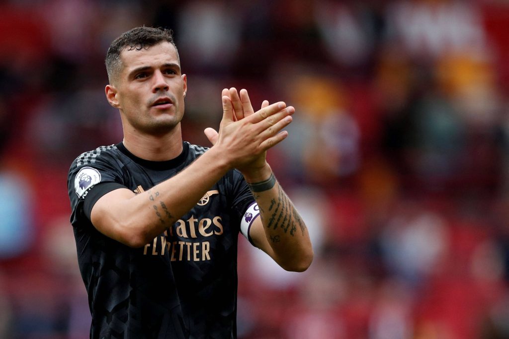 Granit Xhaka clapping in black Arsenal away kit sharp stadium background wallpaper image