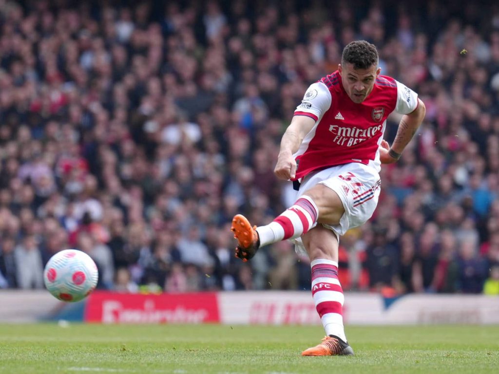 Granit Xhaka striking the ball in Arsenal kit dynamic football action high resolution wallpaper