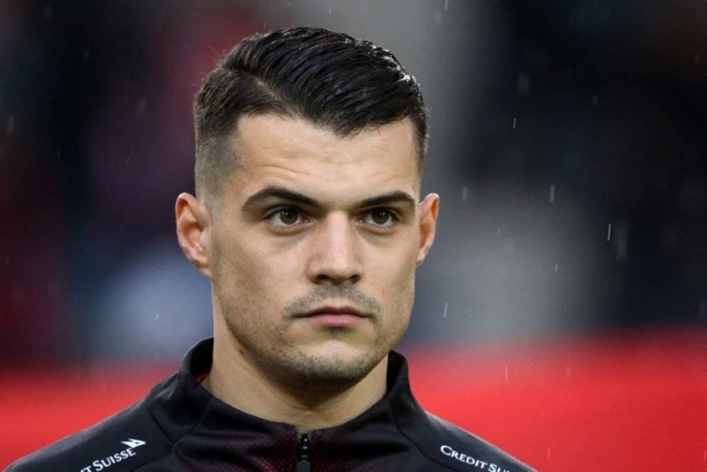 Granit Xhaka close-up portrait sharp haircut black training gear vibrant red background wallpaper