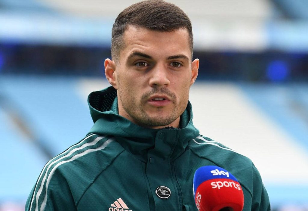 Granit Xhaka in dark green Adidas parka post-match interview stadium background wallpaper