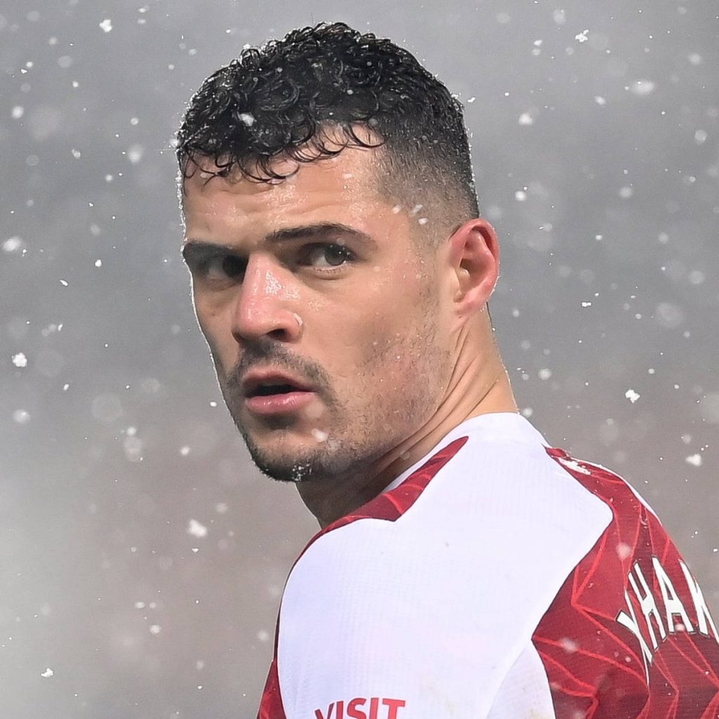 Granite Xhaka close-up in red white kit with falling snowflakes winter football match wallpaper