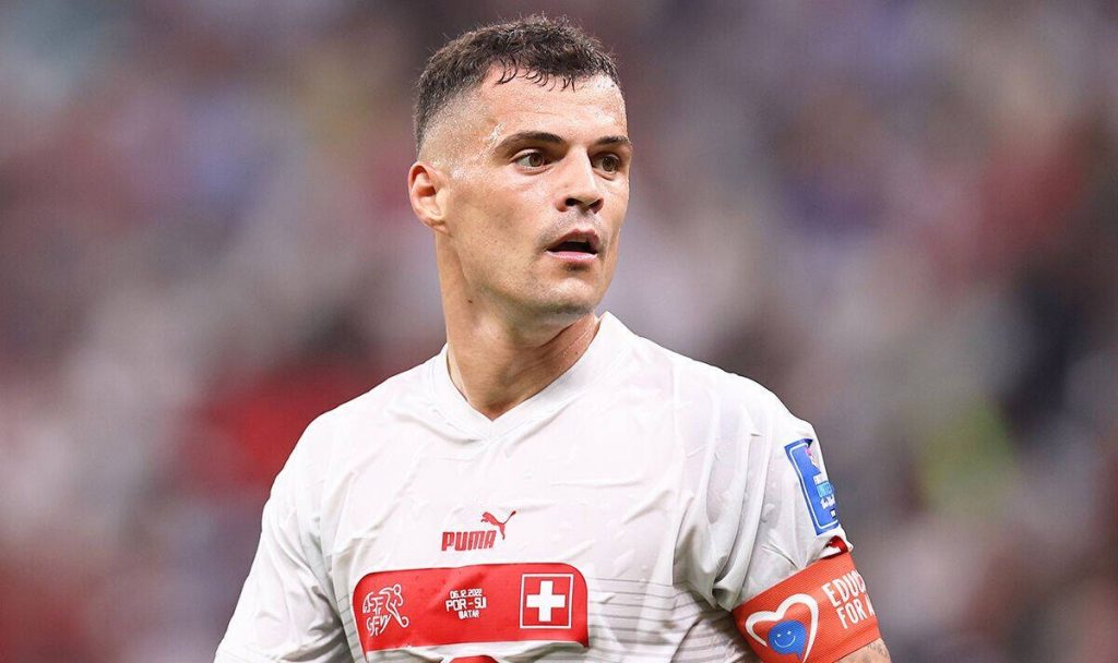 Granit Xhaka in white Swiss kit focused during 2022 World Cup bright stadium wallpaper