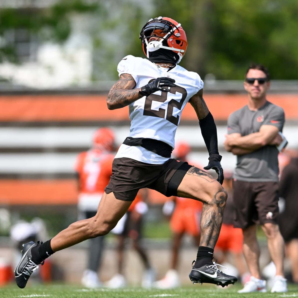 Cleveland Browns safety Grant Delpit in number 22 jersey training on sunny field dynamic action shot Wallpaper