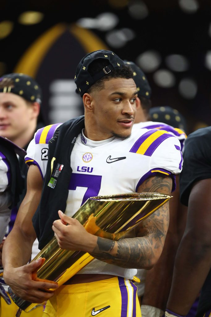 LSU football star Grant Delpit celebrates national championship win with trophy in white jersey Wallpaper
