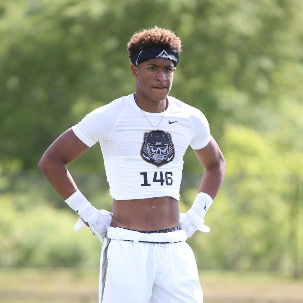 NFL safety Grant Delpit trains outdoors in white Nike shirt and black bandana on green field Wallpaper