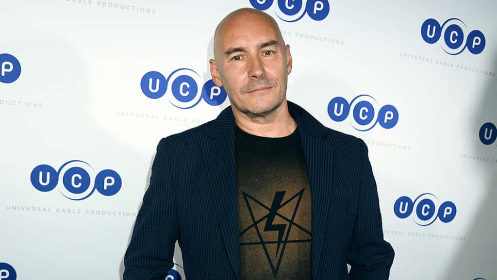 Portrait of comic book writer Grant Morrison in dark blazer and graphic tee at Universal event Wallpaper