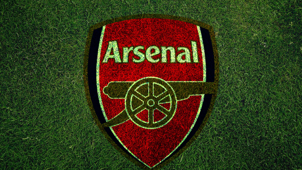 The Pride of Arsenal: Logo on Lush Green Field Wallpaper