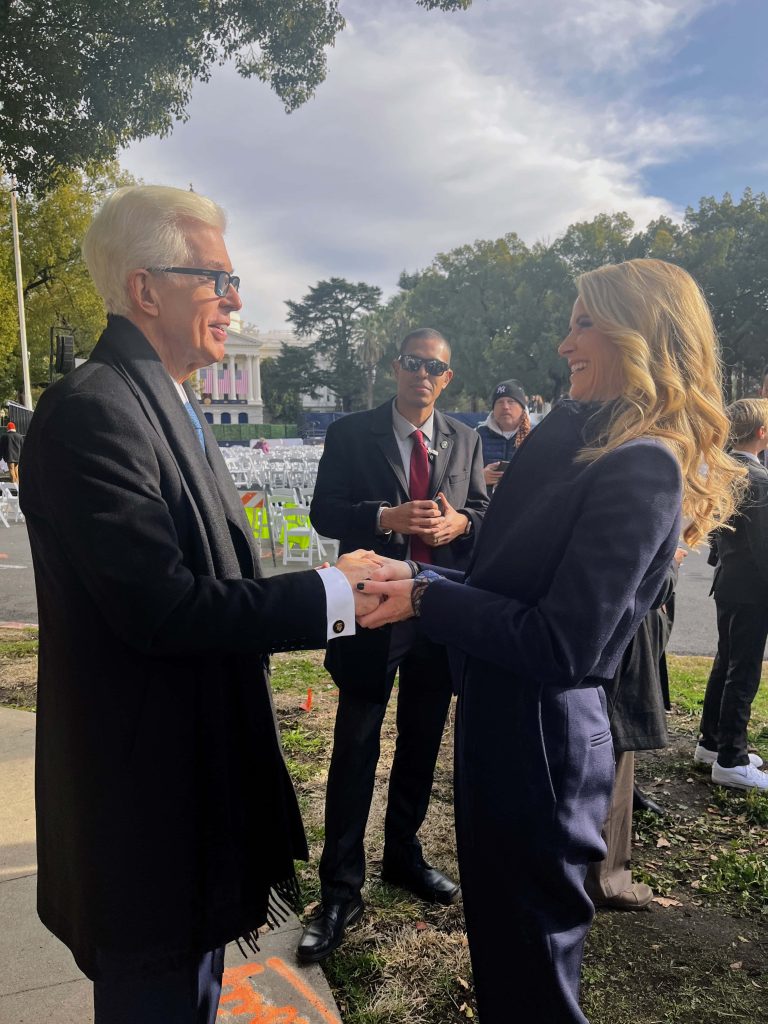 Former California Governor Gray Davis warmly greets a woman near California State Capitol outdoors Wallpaper