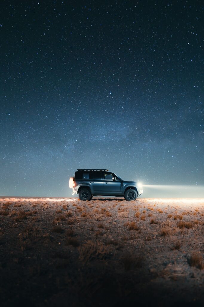 Gray Land Rover Defender Under Starry Night Sky: Stunning Background Wallpaper