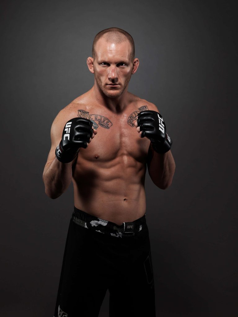 Gray Maynard UFC fighter shirtless in fighting stance with chest tattoos on dark grey background Wallpaper