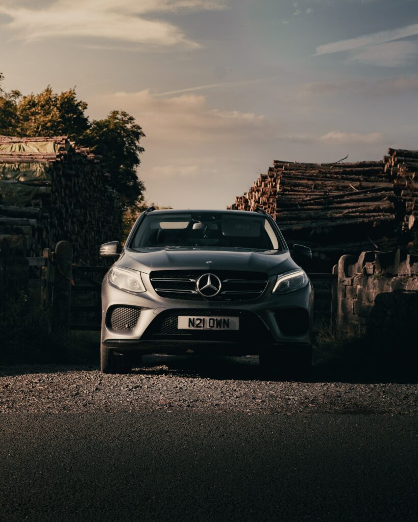 Gray Mercedes SUV on Rustic Road with Dramatic Lighting Wallpaper