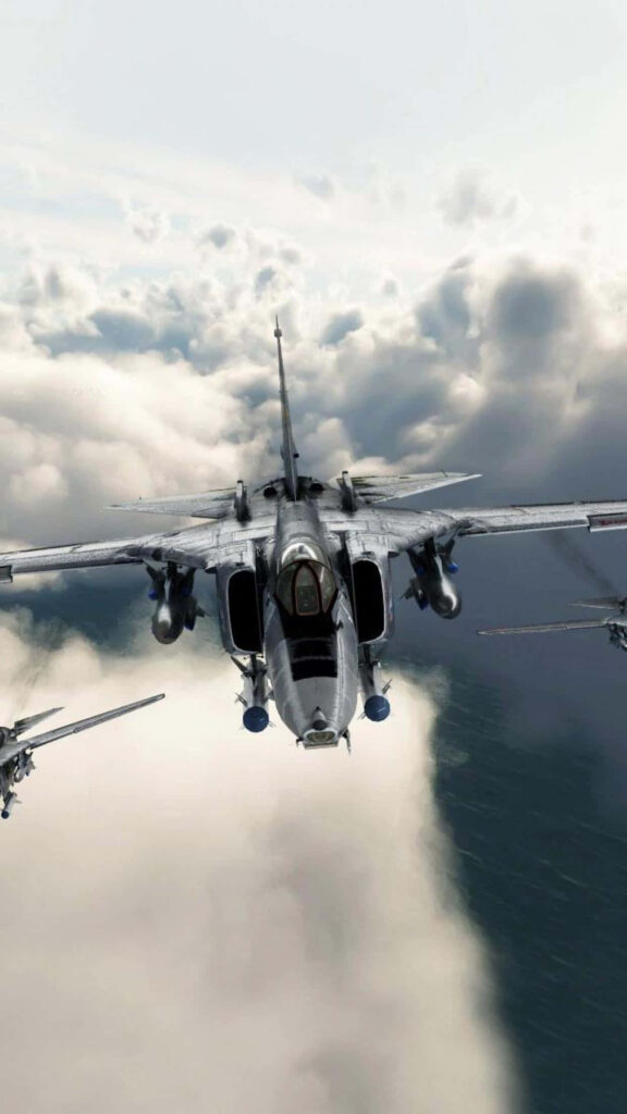 Gray Military Fighter Soaring Amidst Cloudy Skies: Majestic Android Jumbo Jet in the Background Wallpaper