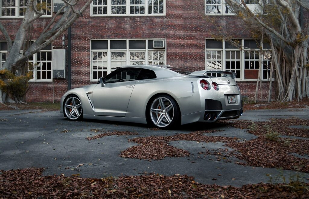 Sleek Gray Nissan GT-R Against Rustic Brick: Urban Autumn Background Wallpaper