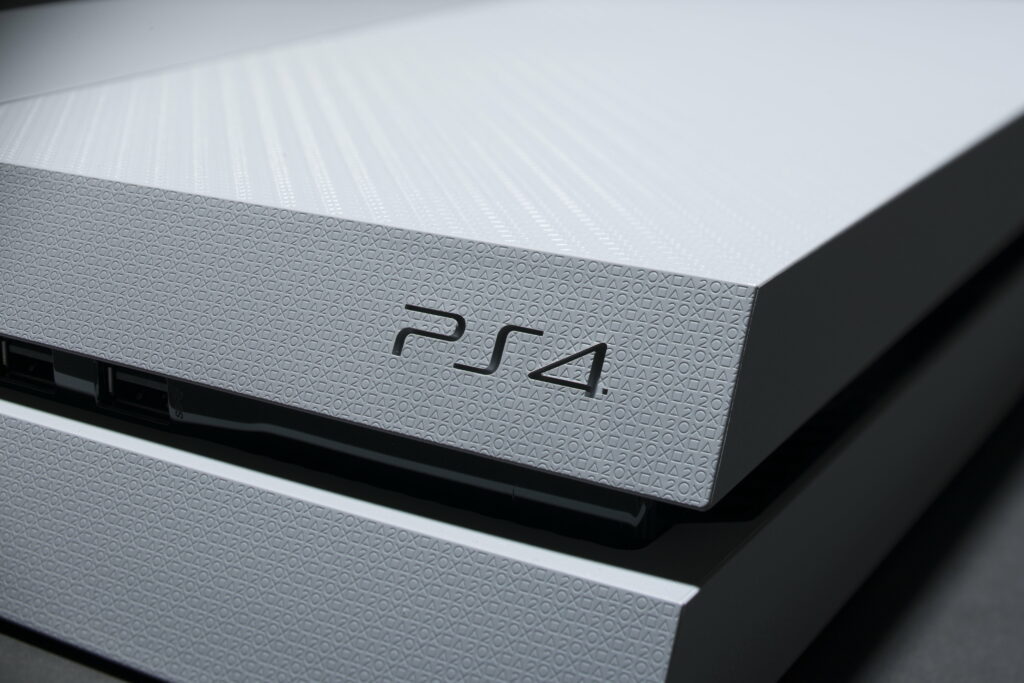 Close-up of white Sony PlayStation 4 console with textured iconic buttons design in soft light Wallpaper