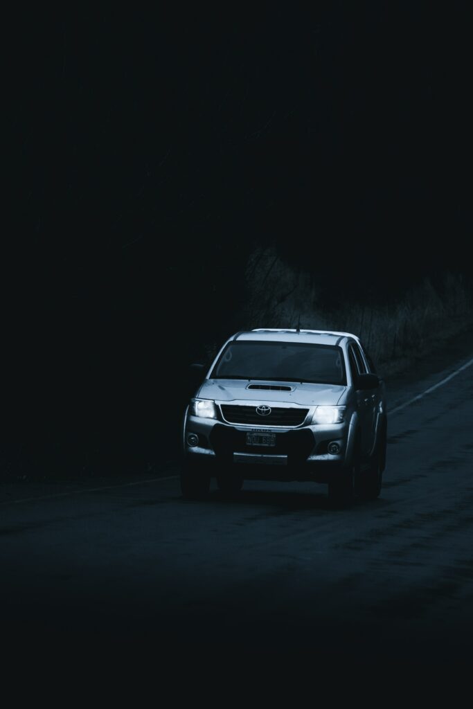 Gray Toyota Hilux on Dark Winding Road - Rugged Adventure Wallpaper