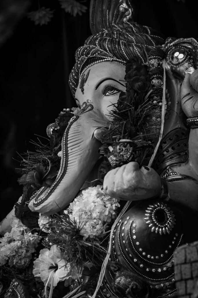 Intricate Grayscale Ganesh Statue Wallpaper with Floral Decor Background