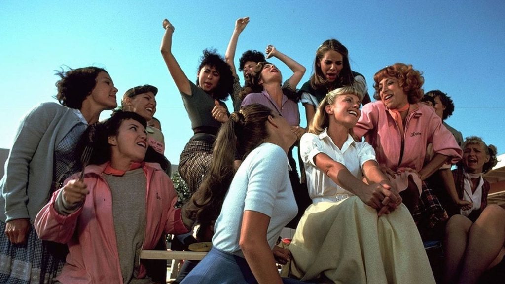 Grease 1978 wallpaper Olivia Newton-John Sandy Pink Ladies cheerful outdoor Rydell High scene