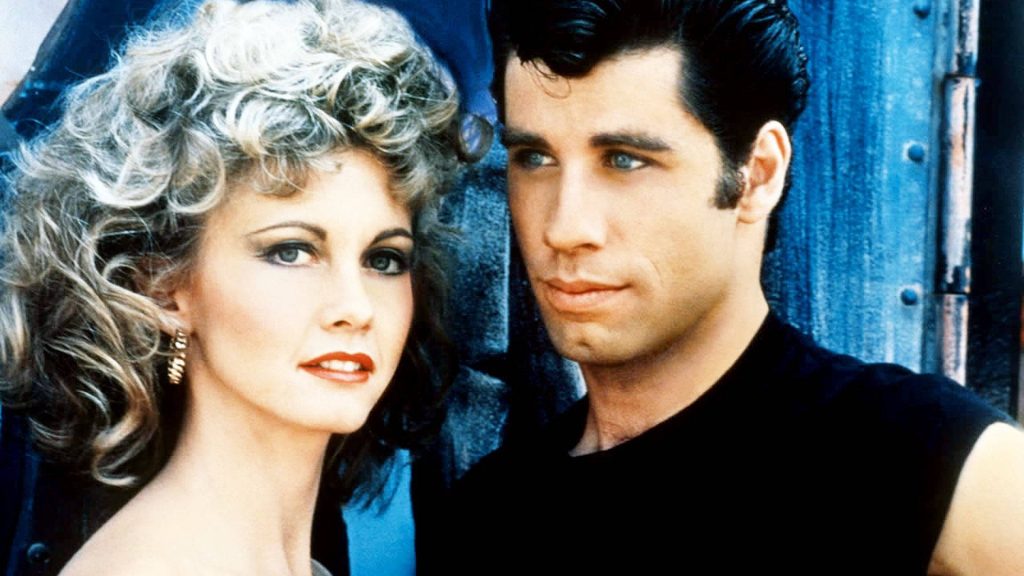 John Travolta and Olivia Newton-John in Grease iconic close-up wallpaper blue background
