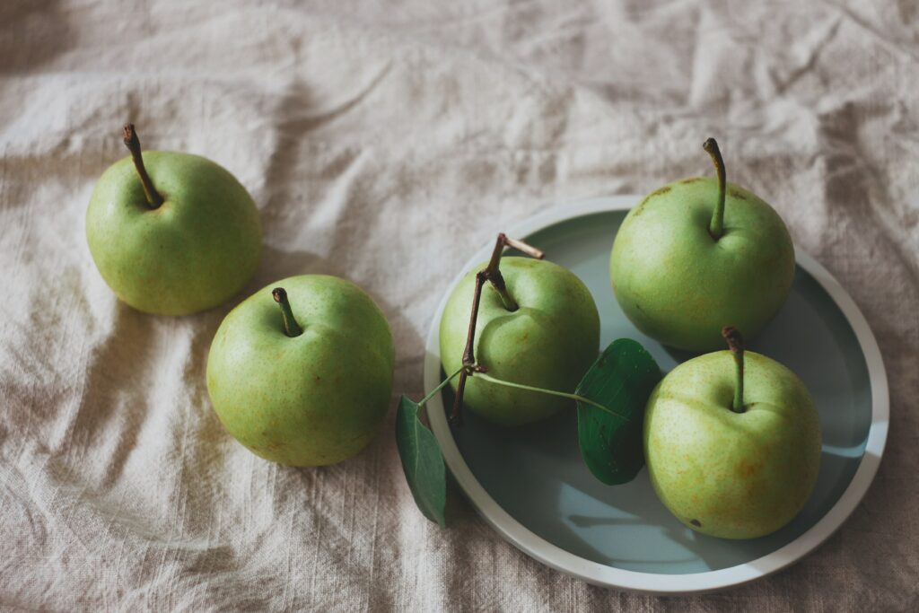 Rustic Green Apples on Plate: Serene Wallpaper Background