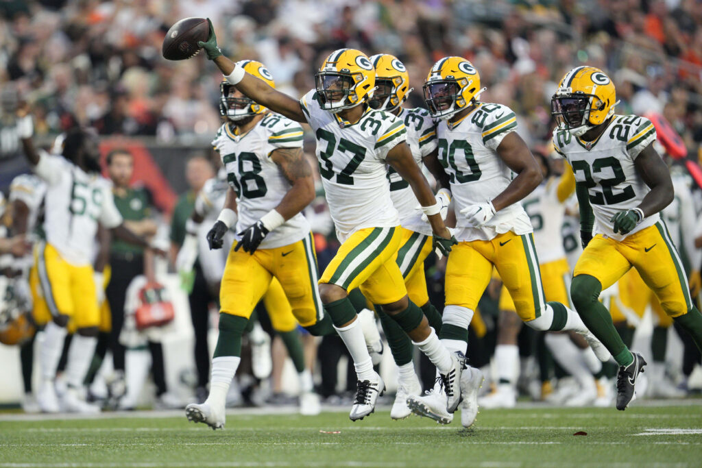 Green Bay Packers players celebrate a big play on field vibrant stadium background wallpaper