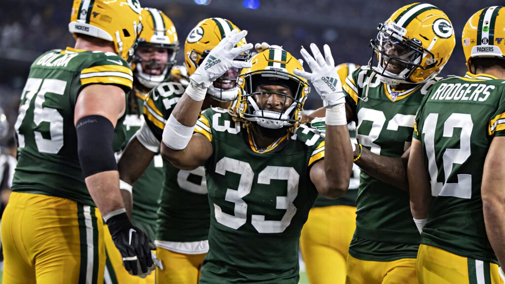 Green Bay Packers NFL players celebrating in green and gold uniforms dynamic sports wallpaper