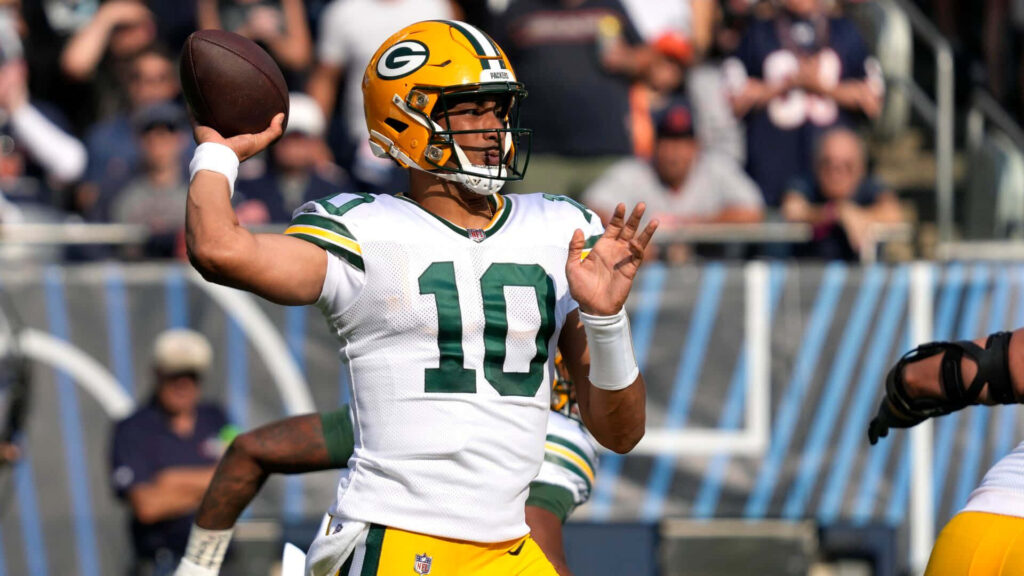 Green Bay Packers quarterback in green and gold uniform ready to throw pass in stadium Wallpaper