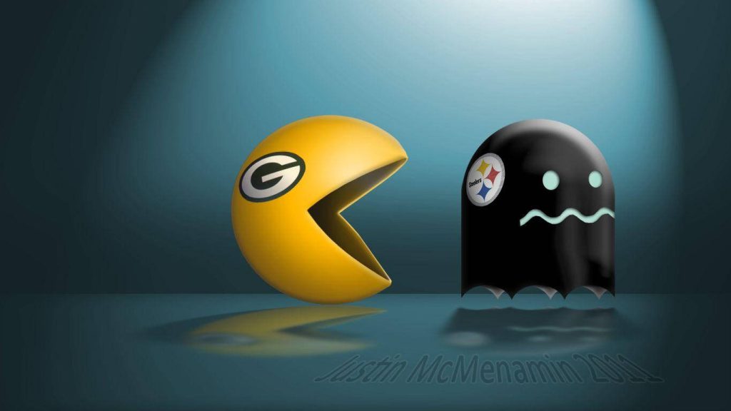 Pac-Man with Green Bay Packers logo chasing Pittsburgh Steelers ghost in blue spotlight wallpaper