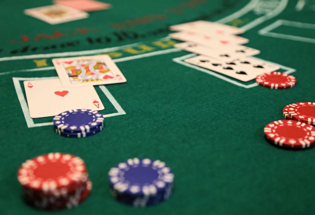 Close-up of green blackjack table with red and blue poker chips and face-up playing cards wallpaper