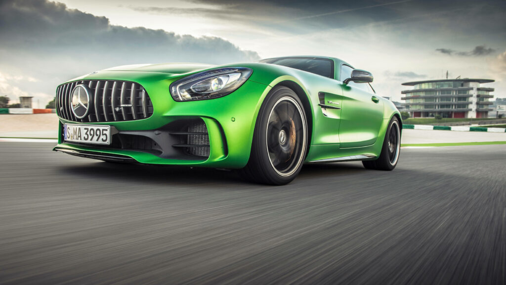 Green Mercedes-AMG speeding on open road high-performance luxury car dynamic motion blur Wallpaper