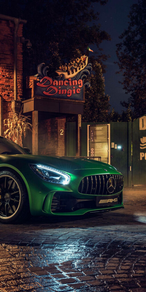 Green Mercedes-AMG parked outside Dancing Dingie at night with warm streetlight glow luxury car Wallpaper