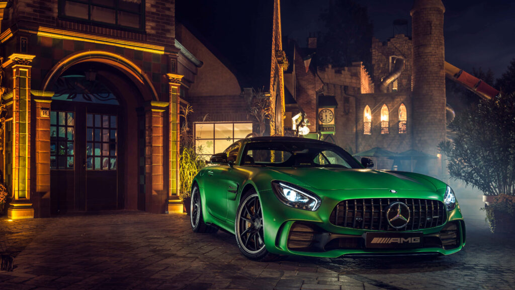 Green Mercedes Benz AMG GT R parked at night by elegant lit urban building luxury sports car Wallpaper