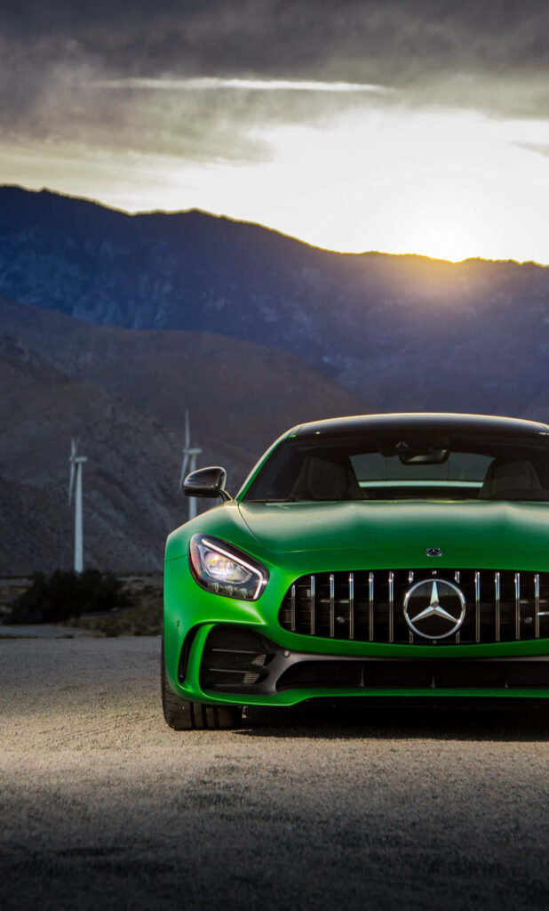 Front view of green Mercedes GTS car in mountain sunset landscape showcasing sleek design Wallpaper