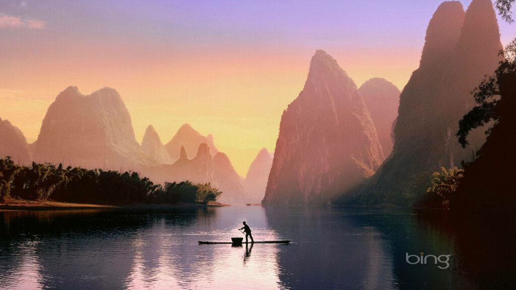 Lone fisherman on Li River Guilin at sunset with karst mountains tranquil nature wallpaper