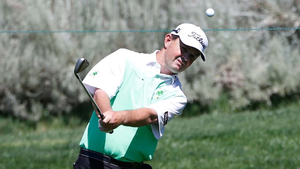 Professional golfer Greg Chalmers swings golf club wearing autism awareness polo on sunny course Wallpaper