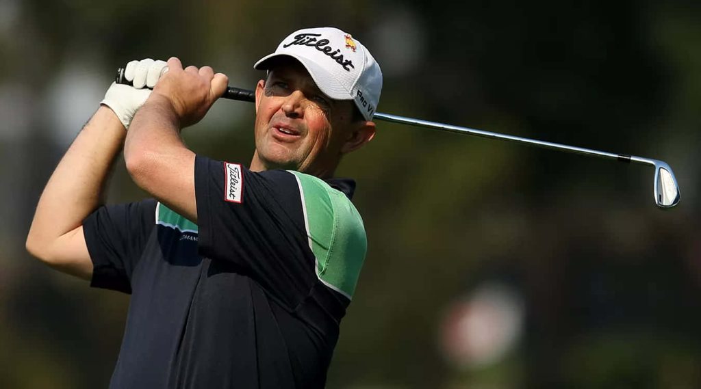 Professional golfer Greg Chalmers mid-swing wearing Titleist cap on blurred golf course background Wallpaper