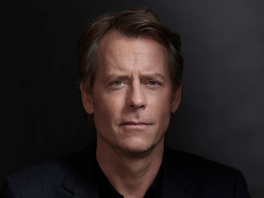 Close-up studio headshot of actor Greg Kinnear in pinstriped blazer with dramatic soft lighting Wallpaper