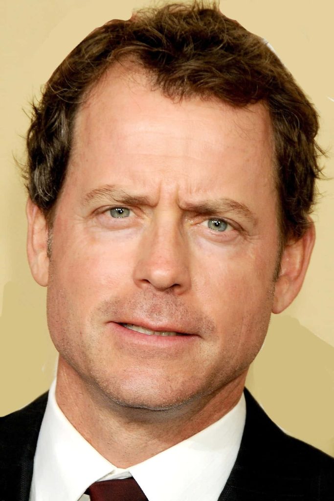 Greg Kinnear close-up portrait in dark suit with neutral beige background classic professional wallpaper