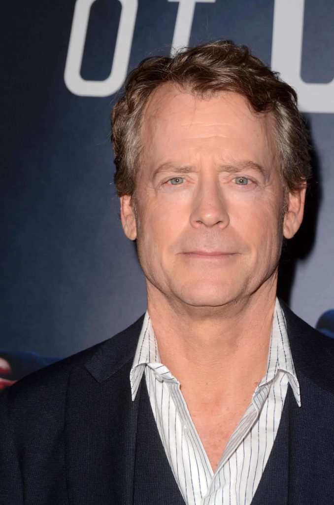 Greg Kinnear close-up portrait in navy suit and pinstriped shirt on red carpet background wallpaper
