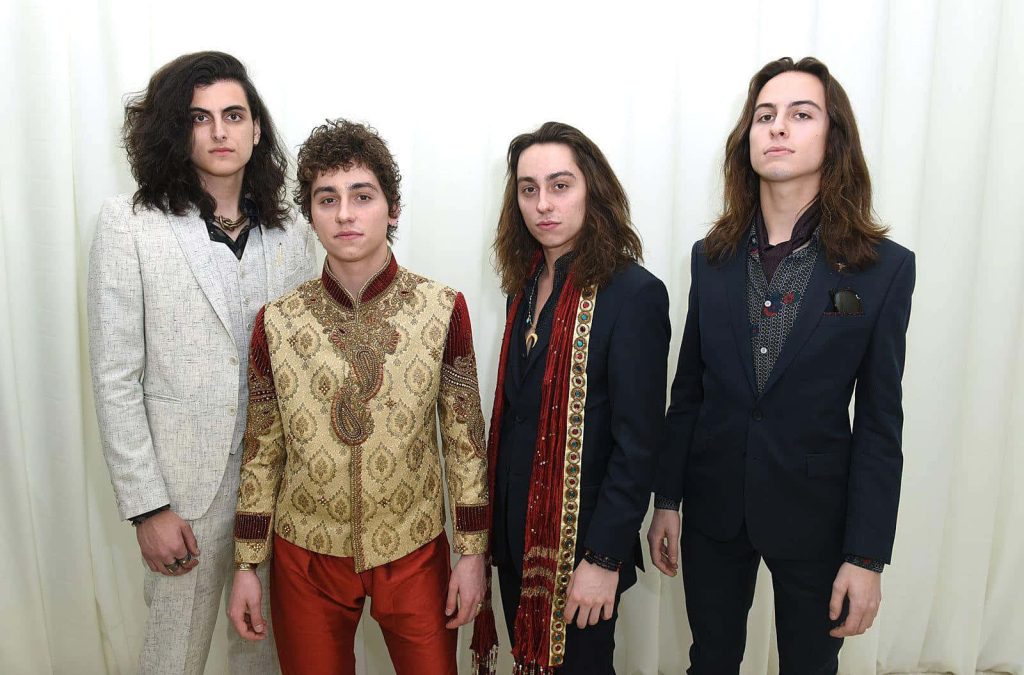 Greta Van Fleet band members in ornate suits posing in bright high resolution rockstar wallpaper