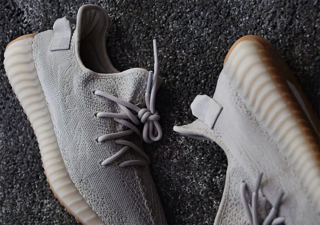 Close-up of grey Adi YEEZY Boost sneakers textured knit and ribbed sole on dark grey background Wallpaper