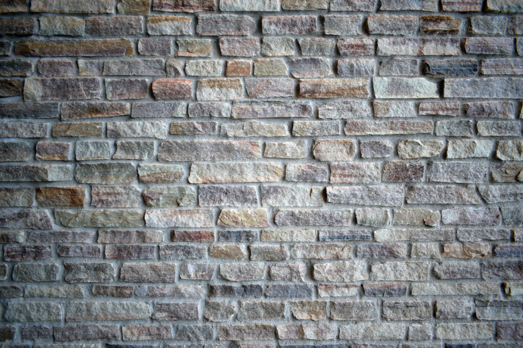 Grey brick wall with natural stone texture rugged masonry earthy tones modern wallpaper background