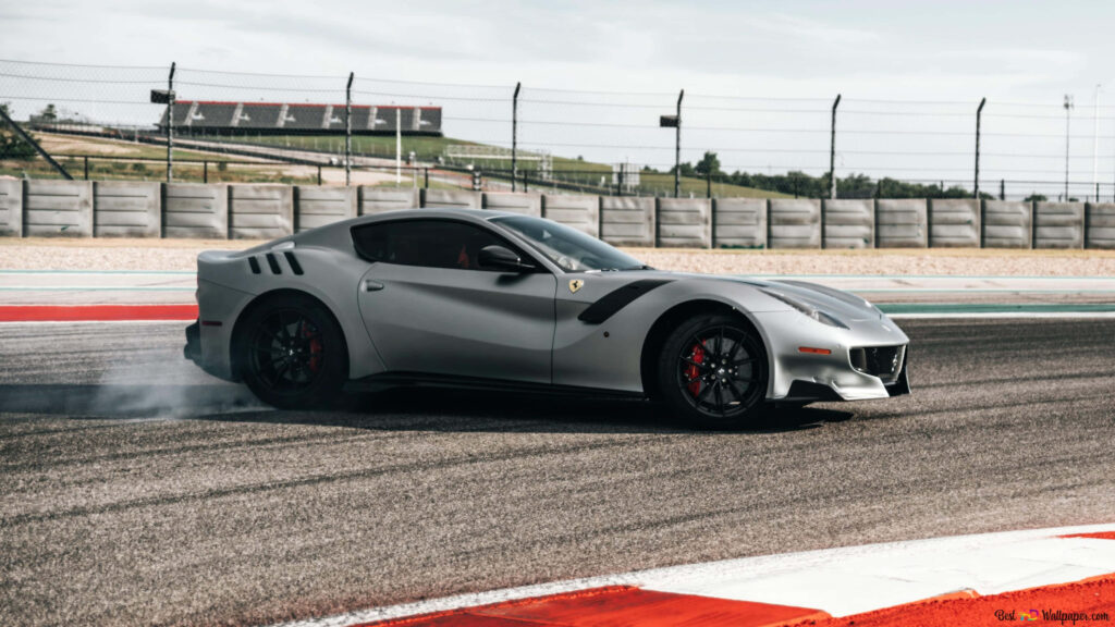 Grey Ferrari speeding through racetrack corner with tire smoke ultra wide 4K racing wallpaper