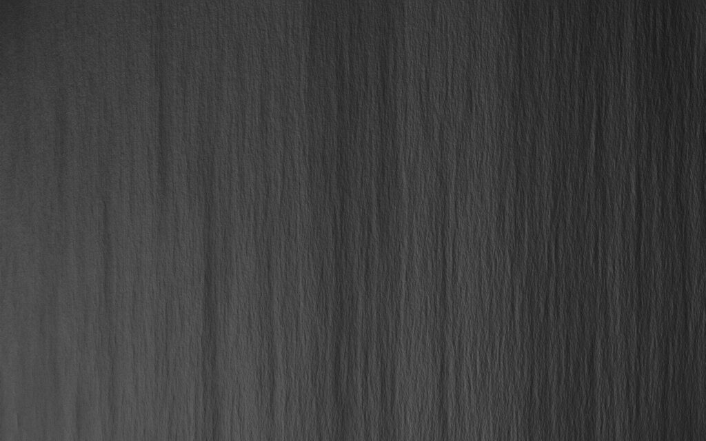 Dark grey textured wallpaper with subtle vertical wrinkles and a rough parchment finish background
