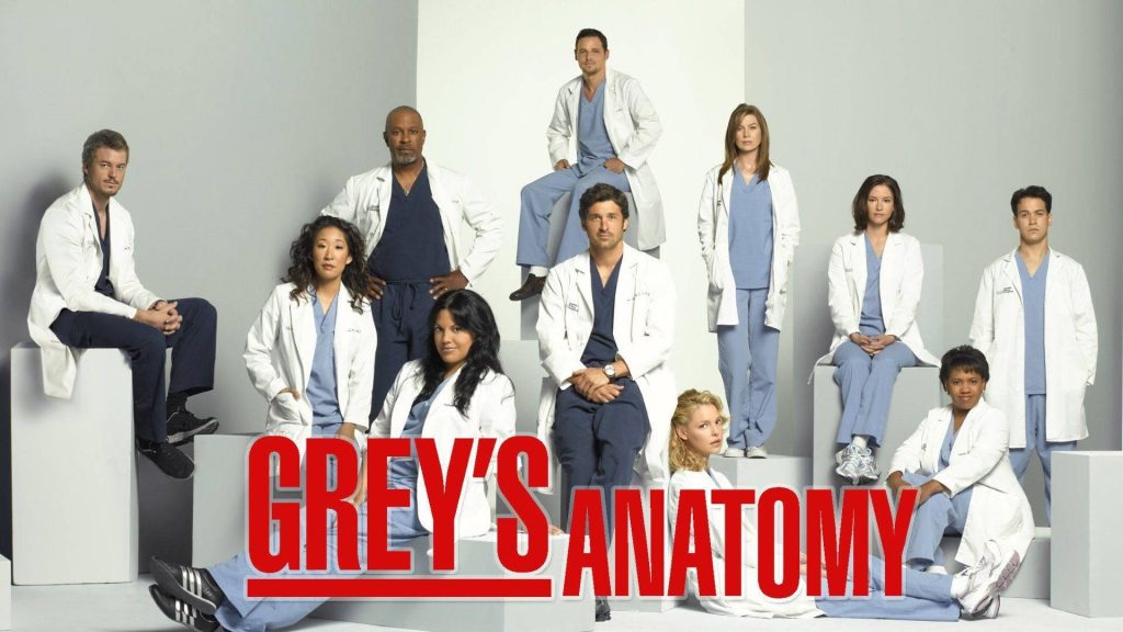 Grey's Anatomy cast in scrubs and lab coats high-quality promotional wallpaper background