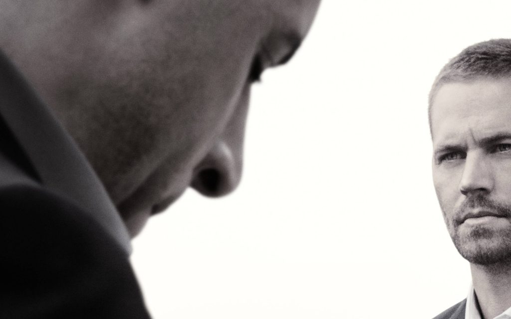 Greyscale Fast and Furious wallpaper with blurred Dom Toretto and focused Brian O'Conner